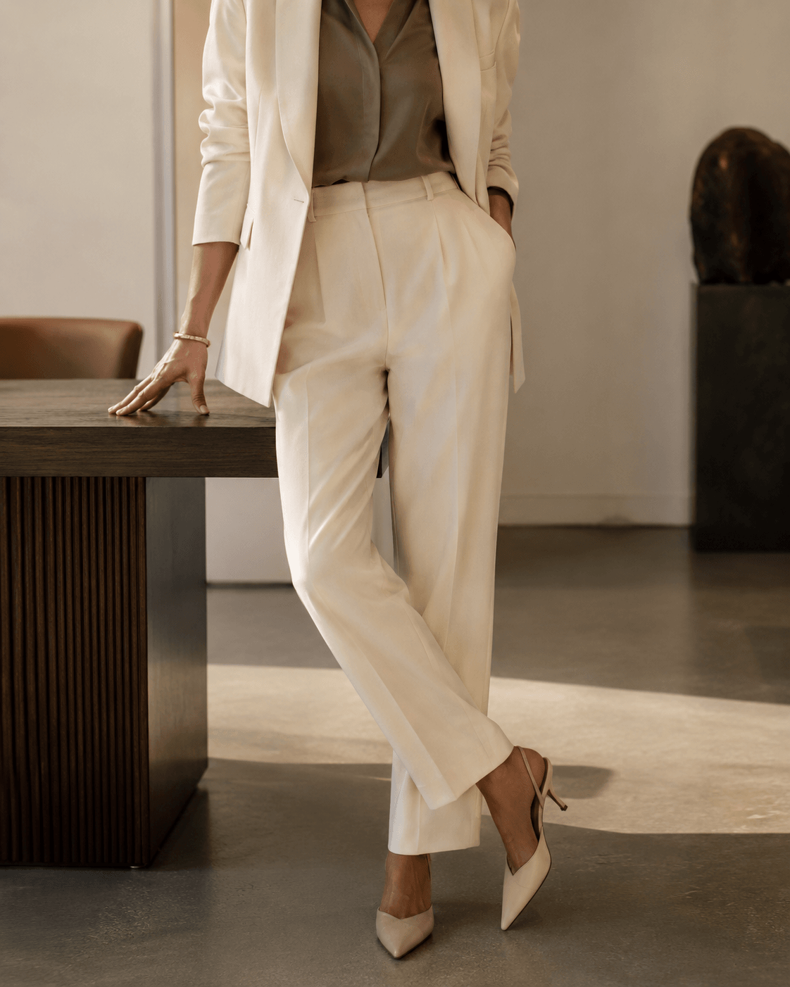 A tailored ivory suit in a neutral, sunlit interior